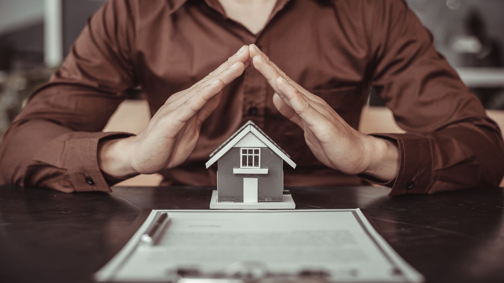 petite maison entouré de mains