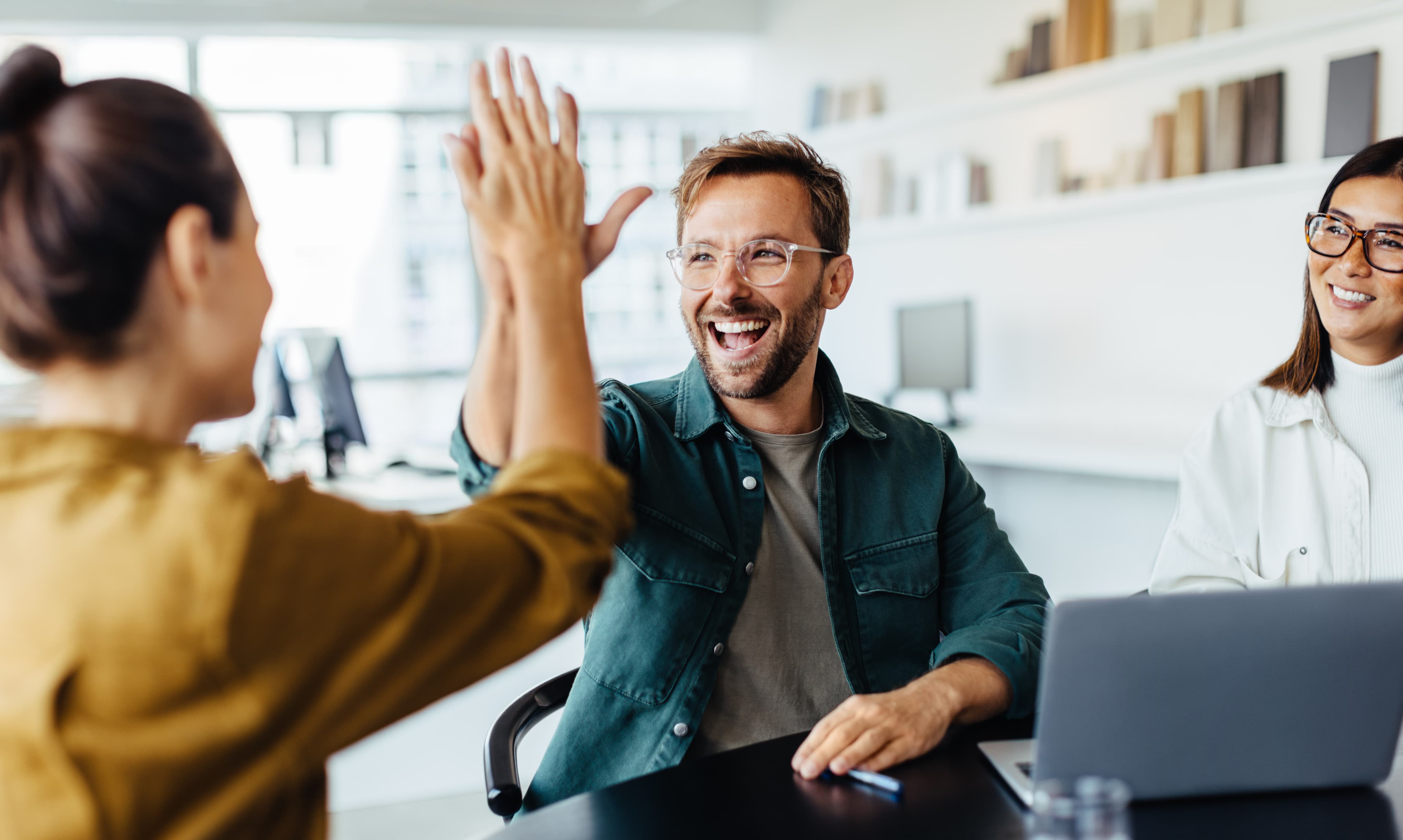 Client heureux qui fait un high five avec un conseiller