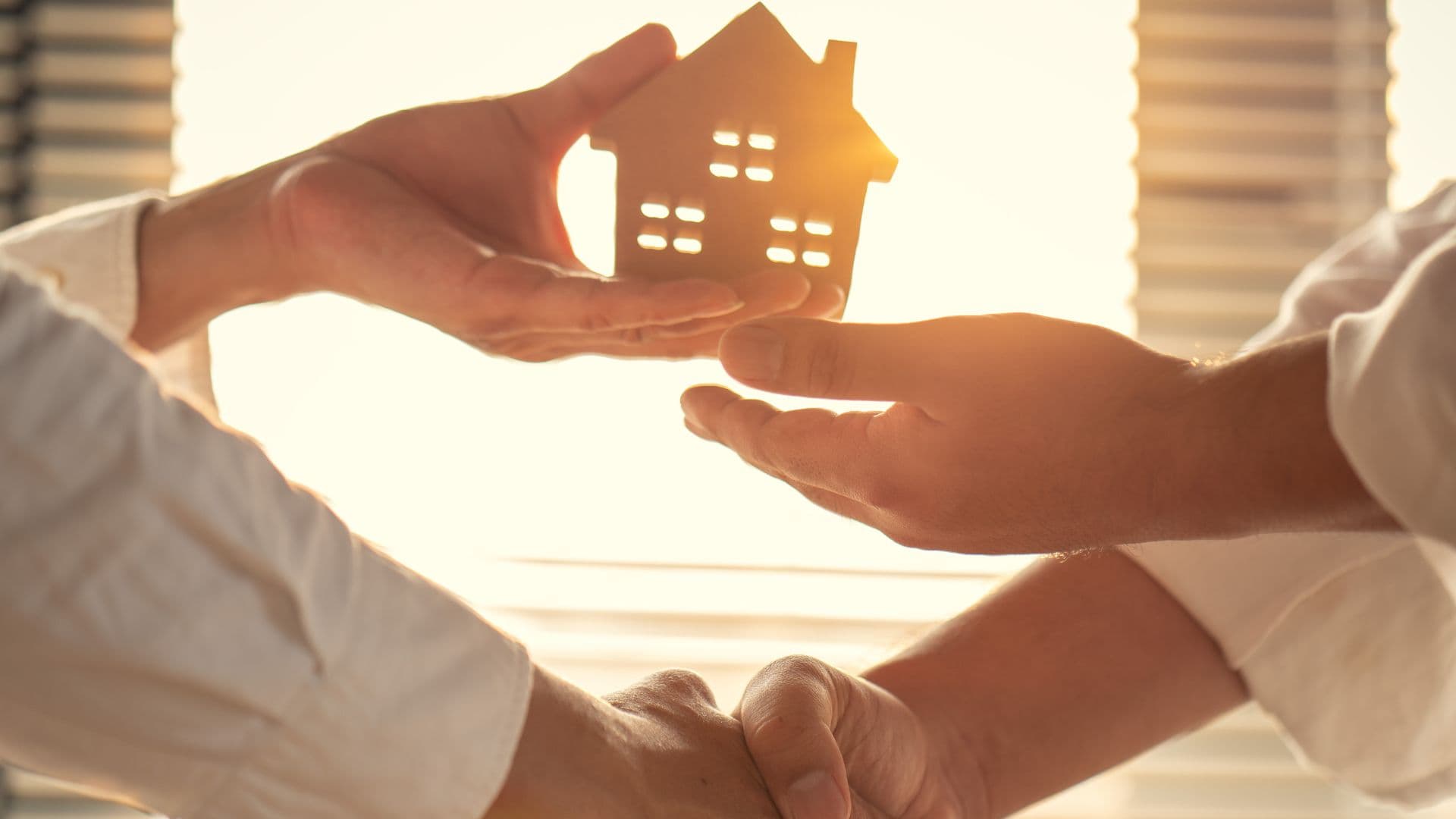 mains qui se croisent et une petite maison