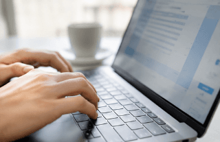mains qui tapent sur un clavier d'ordinateur
